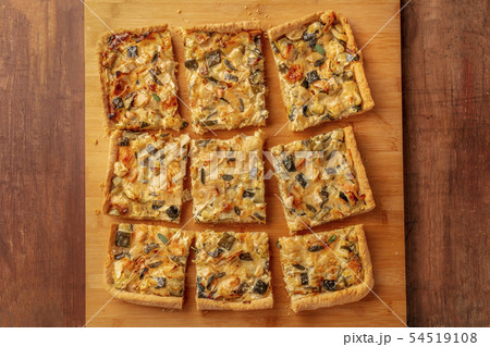 A homemade zucchini and goat cheese pie with sage, shot from the top on a wooden cutting board 54519108