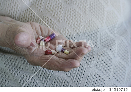 pills on palm of a senior woman pills on palm of a senior woman 54519716
