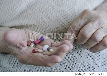 pills on palm of a senior woman 54519717