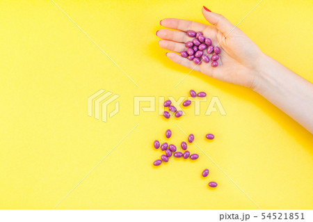 Woman hand holding purple pills handful Woman hand holding purple pills handful 54521851