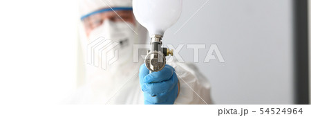 Workman hold in arm airbrush gun wearing protective suit Workman hold in arm airbrush gun wearing protective suit 54524964