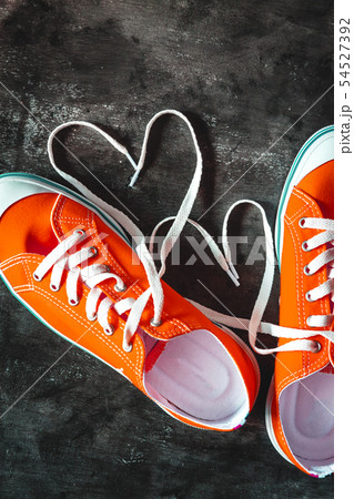 Yellow-orange sneakers on a grunge concrete dark 54527392