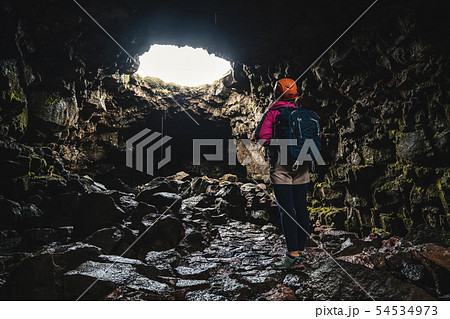 Woman traveler explore lava tunnel in Iceland. 54534973