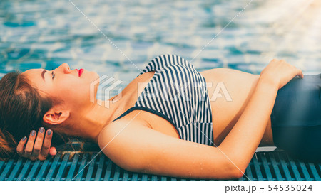 Woman at swimming pool in summer in luxury resort. Woman at swimming pool in summer in luxury resort. 54535024