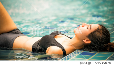 Woman at swimming pool in summer in luxury resort. 54535070