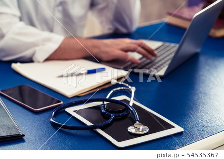 Doctor working in hospital office. 54535367