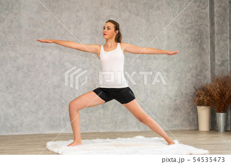 Young woman yoga on carpet at home living room. 54535473