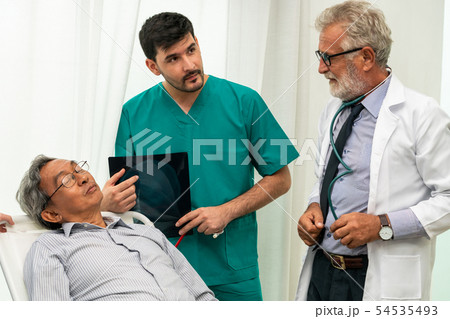 Doctor team work with x ray film image of patient. 54535493