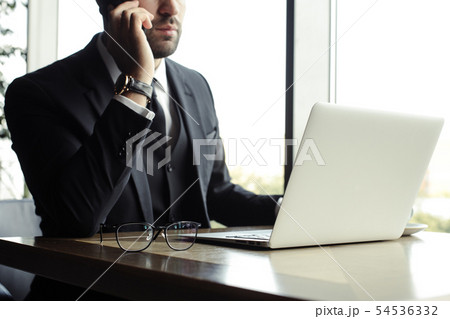 Close up of handsome businessman, working on laptop in restaurant 54536332