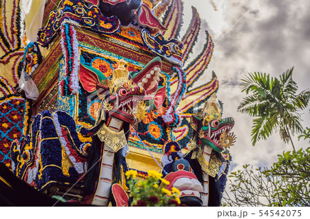 Bade cremation tower with traditional balinese sculptures of demons and flowers on central street in 54542075