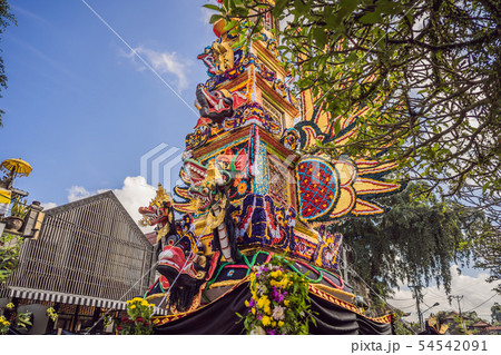 Bade cremation tower with traditional balinese sculptures of demons and flowers on central street in 54542091