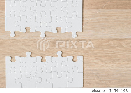 Jigsaw puzzle game piece on light cream brown wood 54544198