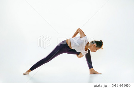 Sporty young woman doing yoga practice isolated on white background 54544900