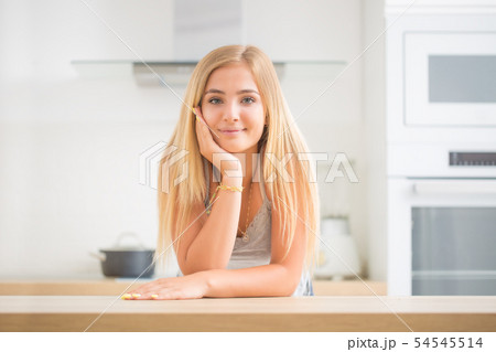 Young cheerful blonde girl in the house kitchen. 54545514