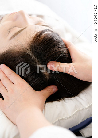 頭皮マッサージを受ける女性と施術者の手元 54545713