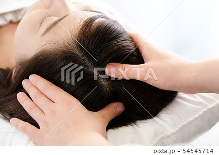 頭皮マッサージを受ける女性と施術者の手元 頭皮マッサージを受ける女性と施術者の手元 54545714