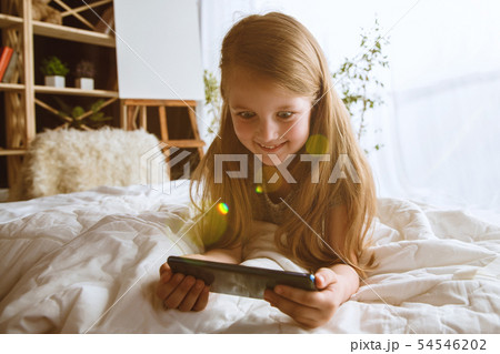Little girl using different gadgets at home 54546202
