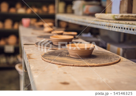 Cups on the shelves in the pottery workshop 54546325