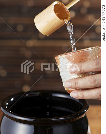 甕に入った焼酎をひしゃくで注ぐ 甕に入った焼酎をひしゃくで注ぐ 54547672