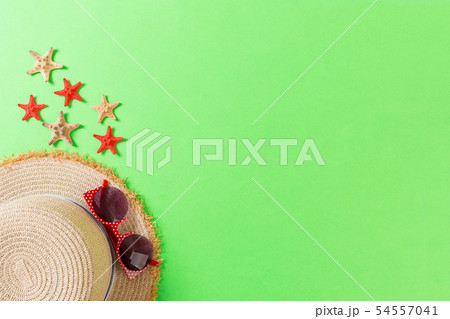 Beach hat with seashells on brown green table. Beach hat with seashells on brown green table. 54557041