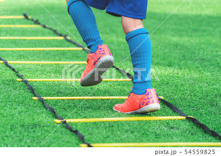 Child feet with soccer boots training on agility Child feet with soccer boots training on agility 54559825