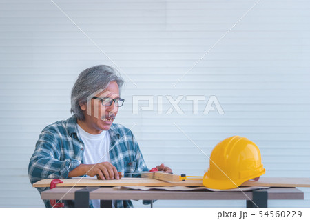 Old Construction Builder with tools and paper plan Old Construction Builder with tools and paper plan 54560229