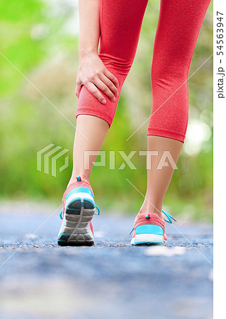 Muscle injury - woman running clutching calf muscle Muscle injury - woman running clutching calf muscle 54563947