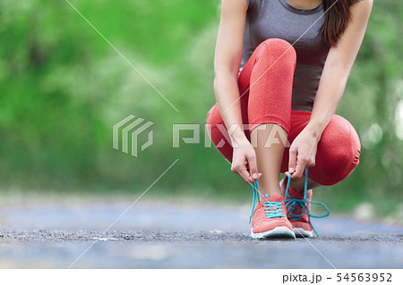 Running shoes - closeup of woman tying shoe laces Running shoes - closeup of woman tying shoe laces 54563952