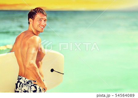 Surfer man going surfing on summer beach 54564089