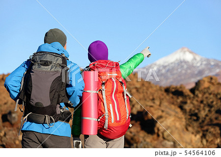 Hikers looking at view pointing hiking in mountain 54564106