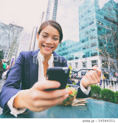 Young business woman on smartphone in lunch break 54564351