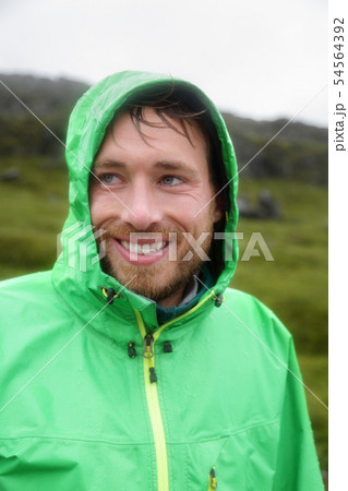 Rain jacket - man smiling outdoors on rainy day Rain jacket - man smiling outdoors on rainy day 54564392