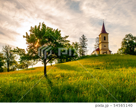 Small church in the middle of lush green spring landscape on sunny day. St. Peter and Pauls church Small church in the middle of lush green spring landscape on sunny day. St. Peter and Pauls church 54565140