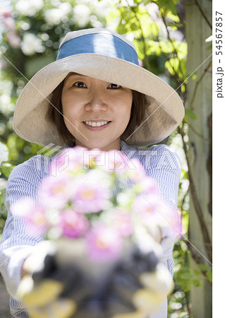 ガーデニングイメージ　花の苗を差し出す女性 54567857