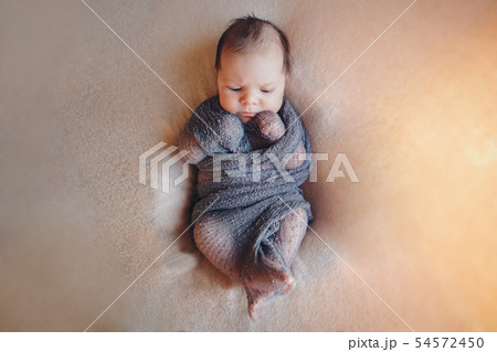 newborn baby sleeps wrapped in a blanket newborn baby sleeps wrapped in a blanket 54572450