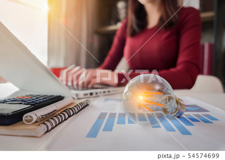 Women use laptop to work and have bulbs as a conc Women use laptop to work and have bulbs as a conc 54574699