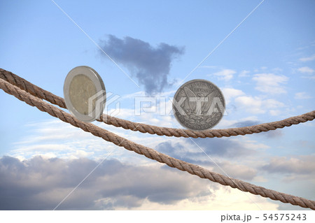2 Euro coin and one dollar coin balancing on rope 2 Euro coin and one dollar coin balancing on rope 54575243