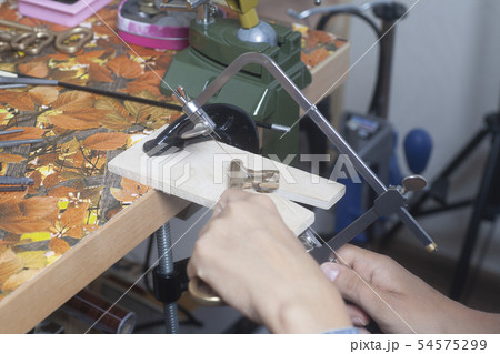 Jeweler working with jewerly saw. 54575299