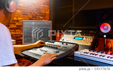 male sound engineer mixing music in home studio 54577676