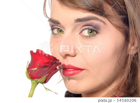 smiling girl dressed in a black cape smells a red 54580206