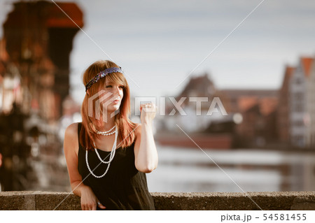 Flapper girl woman in1920s style standing on the Flapper girl woman in1920s style standing on the 54581455