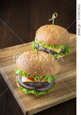 Fresh two beef burgers with vegetables on board Fresh two beef burgers with vegetables on board 54581922