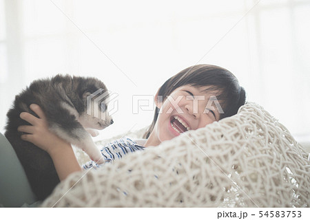 asian child playing with siberian husky puppy asian child playing with siberian husky puppy 54583753