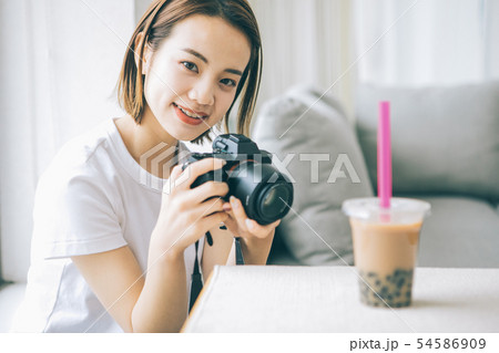 カメラでタピオカミルクティーを撮る若い女性 54586909