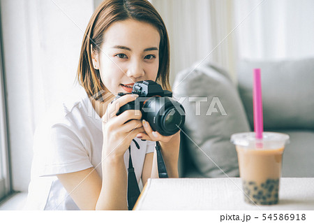 カメラでタピオカミルクティーを撮る若い女性 54586918