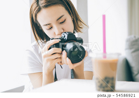 カメラでタピオカミルクティーを撮る若い女性 カメラでタピオカミルクティーを撮る若い女性 54586921