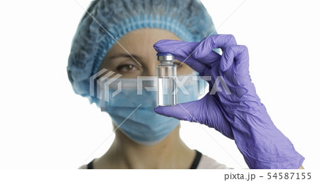 Female scientist holding ampoule in hand Female scientist holding ampoule in hand 54587155