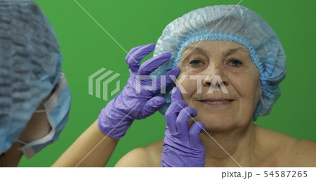 Smiling elderly female in protective hat. Plastic Smiling elderly female in protective hat. Plastic 54587265