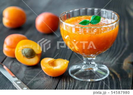 Glass vase of apricot jam 54587980