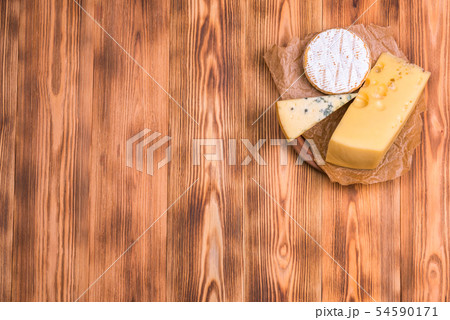 view from the top. pieces of different cheese on a wooden table. copy space 54590171